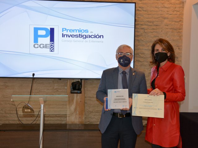 Adolfo Romero recibe el premio en el ámbito familiar y comunitaria de Eva García Perea, directora del departamento de Enfermería de la Universidad Autónoma y miembro del jurado